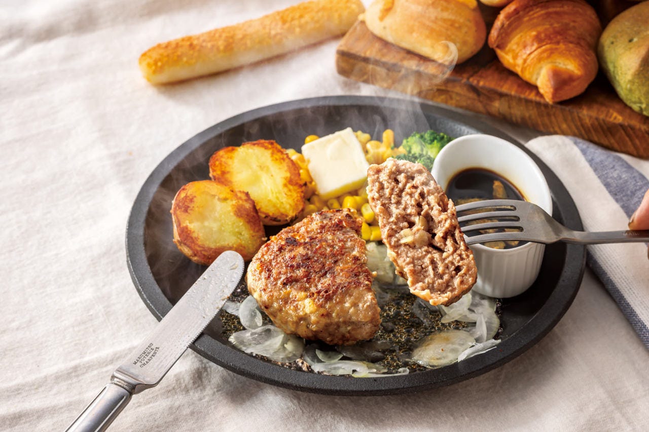 テーブルにビーフハンバーグ ガーリック醤油とパンが置かれている