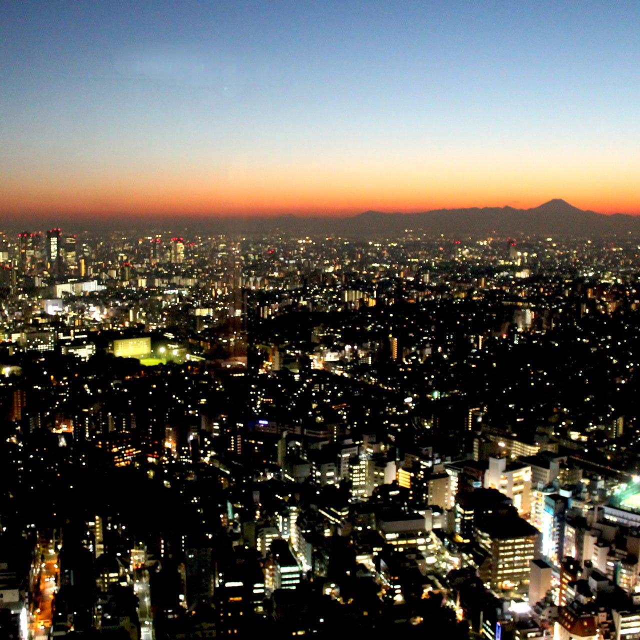 夕暮れの富士山と夜景に変わる新宿の摩天楼をお楽しみください