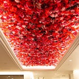 天井の色鮮やかな赤い花の装飾が華やかな雰囲気を演出
