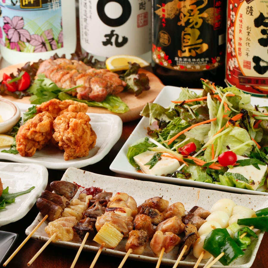 テーブルに並べられた焼鳥やサラダなどの料理