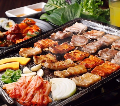 韓友家の「サムギョプサル+20種類韓国料理」がテーブルにならんだ様子