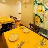 白い壁に映える黄色いテーブルクロス、爽やかなテーブル席