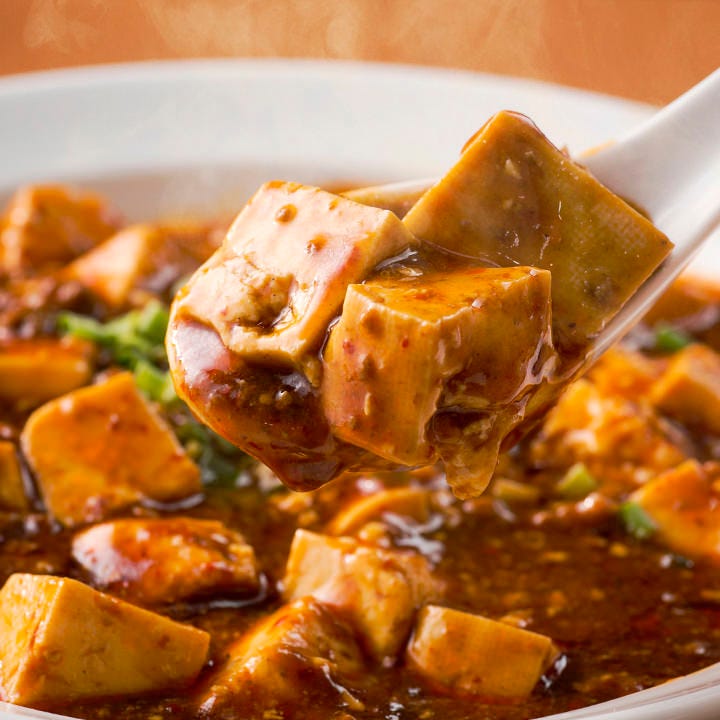 豆腐がたっぷり入った四川マーボー豆腐をレンゲですくっている様子