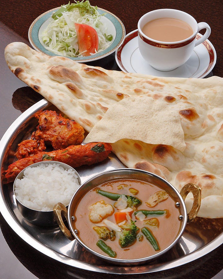 銀のお盆にのったカレーやナン、タンドール料理など