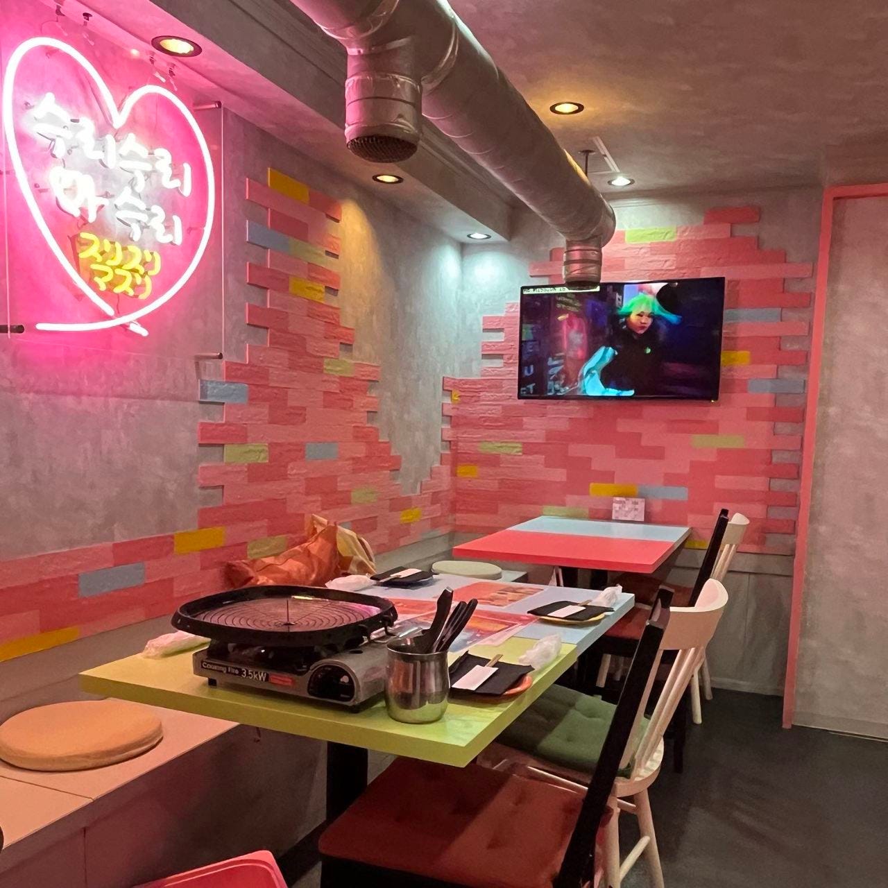 ピンクのネオンが照らす「韓国居酒屋 韓味 上野本店」の店内