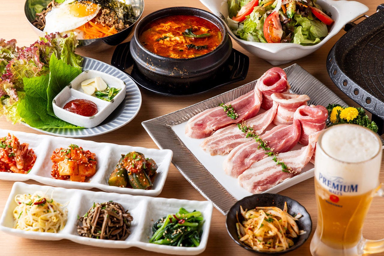 テーブルに並んだサムギョプサルやスンドゥブ、おつまみ