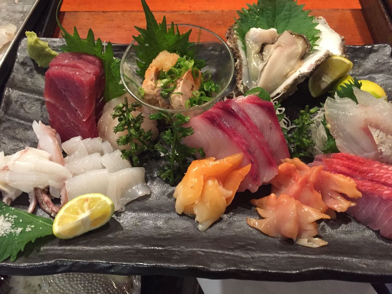 四角い陶器の皿に刺身が盛られたお造り盛り合わせ定食