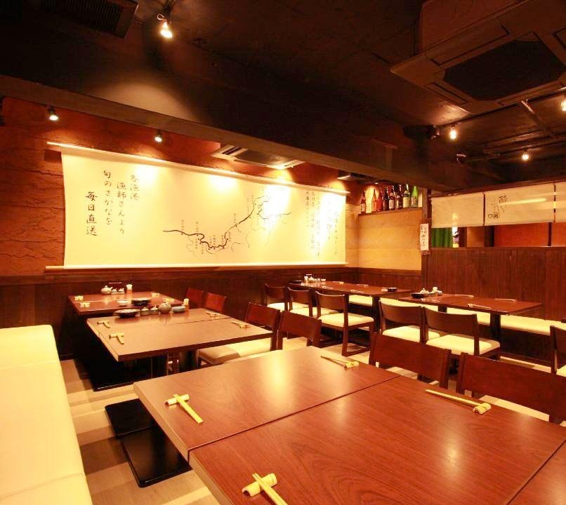 和モダンな雰囲気が漂うさかなさま 北千住本店のテーブル席が並んでいる様子