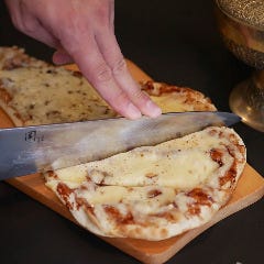 焼きたてで提供する当店名物 タンドゥール窯焼きナンで作るピザ