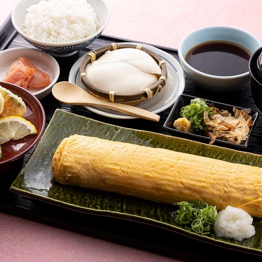 黒いお盆にのっただし巻き、ご飯、ざるどうふ、天ぷら、明太子