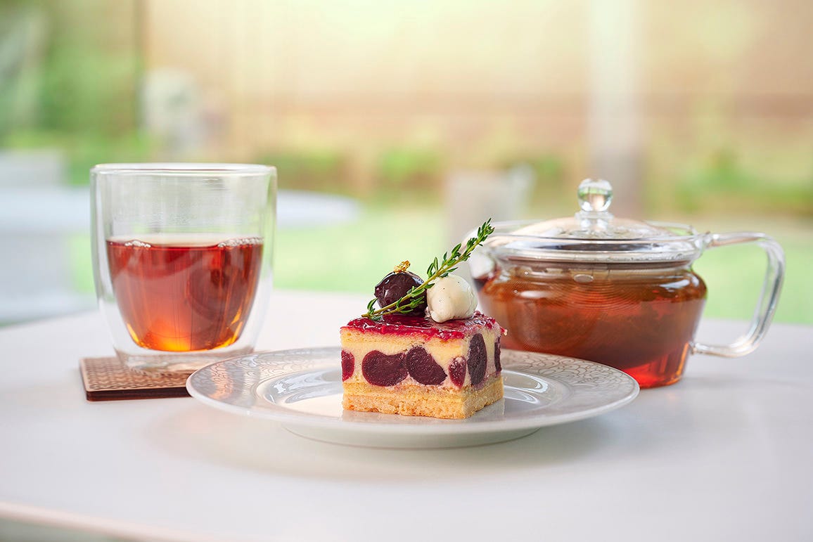 白いテーブルに置かれたカフェテイエンのケーキと紅茶