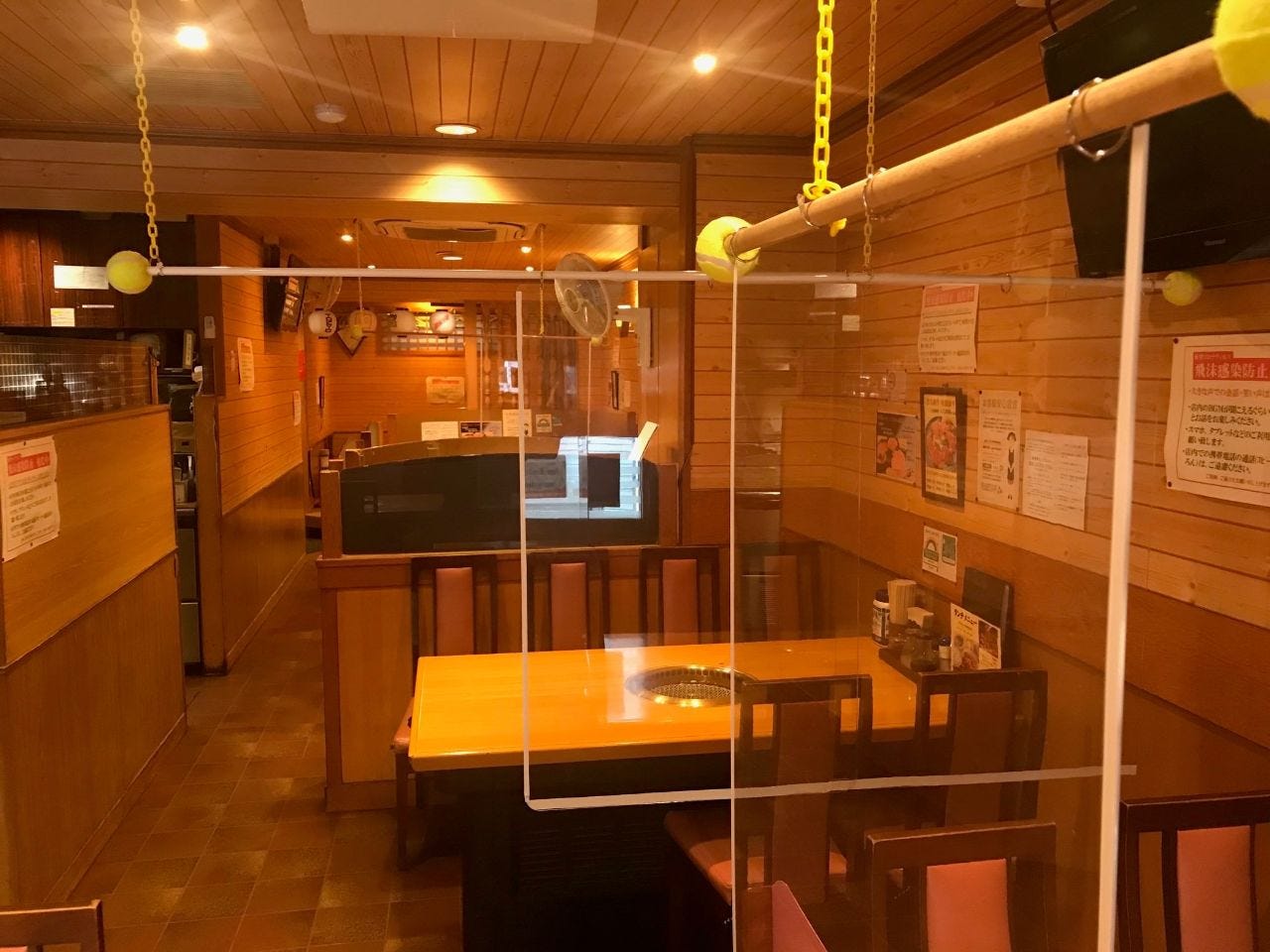 オレンジの照明で照らされ、テーブル席で構成された好味亭店内