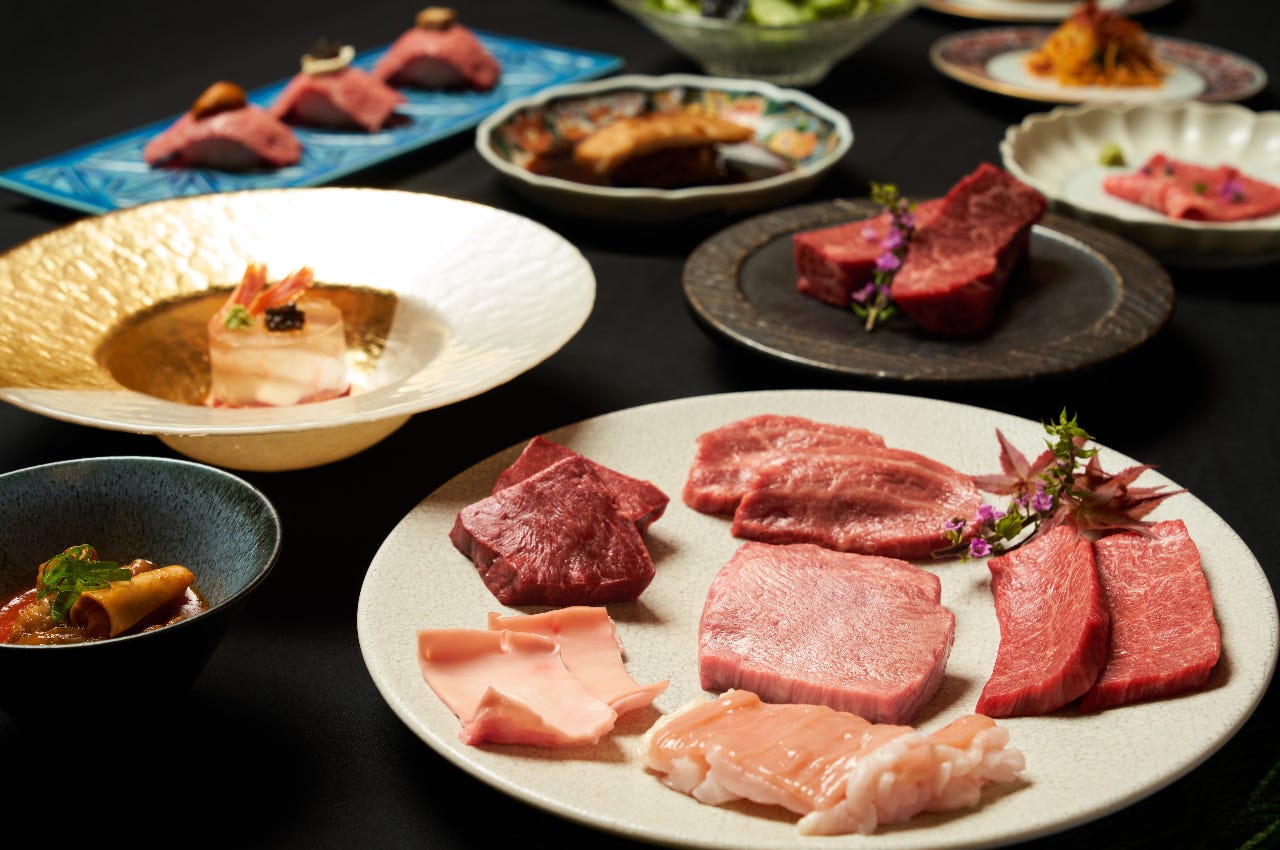 焼肉の肉や肉寿司などの肉料理が並ぶテーブル