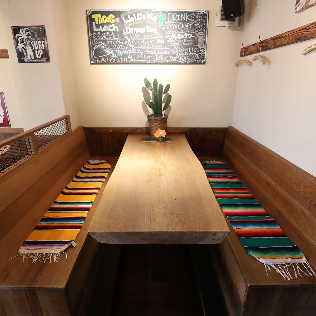 木の長いすにテーブル、観葉植物が置かれた席