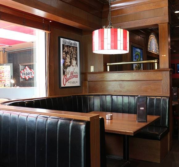 黒いソファーシートでゆっくり過ごせる、木の壁と赤いランプがおしゃれな店内