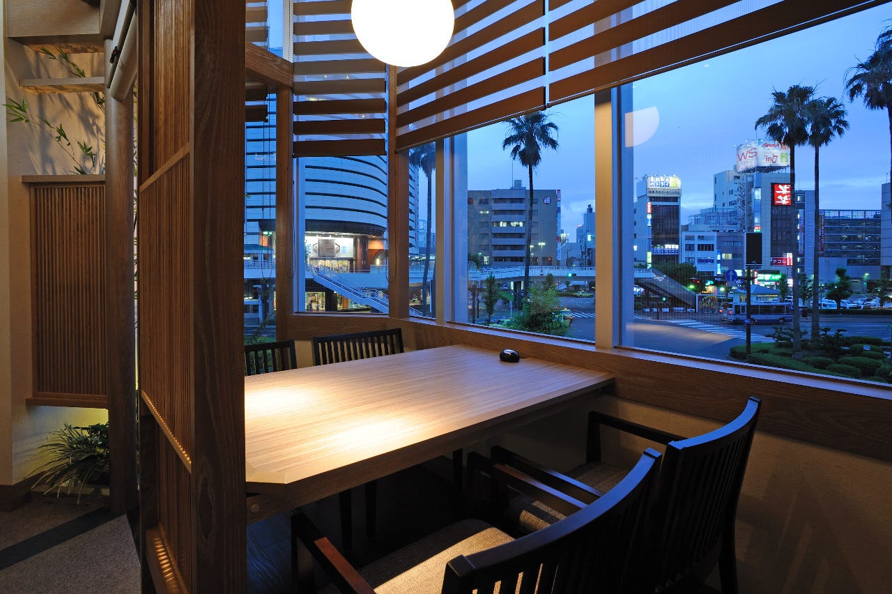 半個室になったテーブル席が大きな窓の下にある阿波の彩り びざんの店内