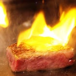 自慢の黒樺牛ステーキを炎で包んで香りづけするフランベ