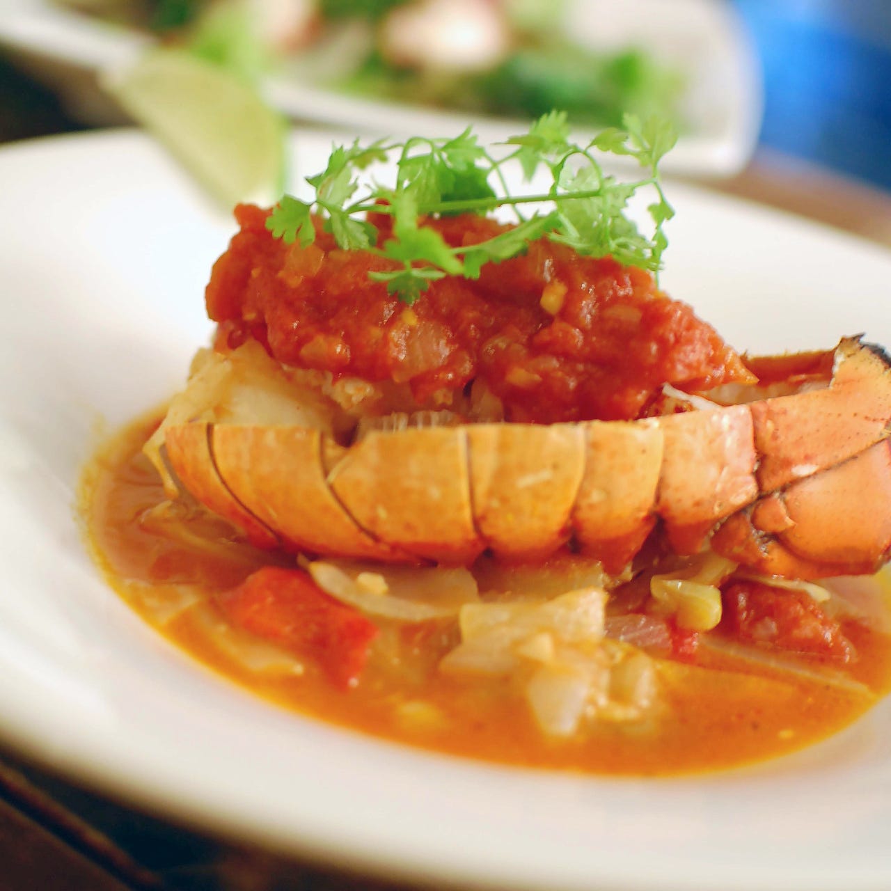 白皿にオマール海老を使った料理が盛り付けられている様子