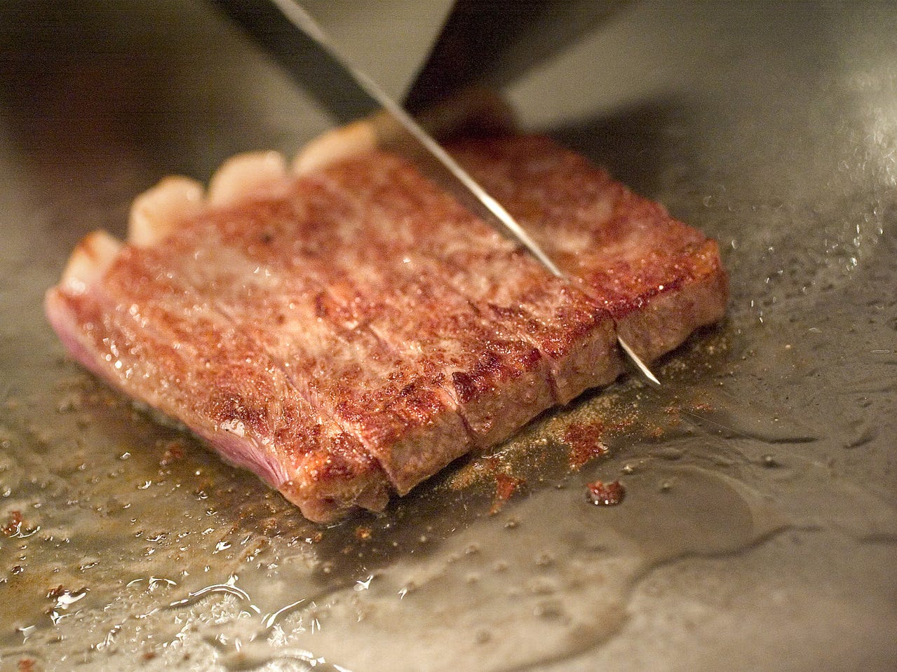 和黒 新神戸店のステーキをカットしている様子