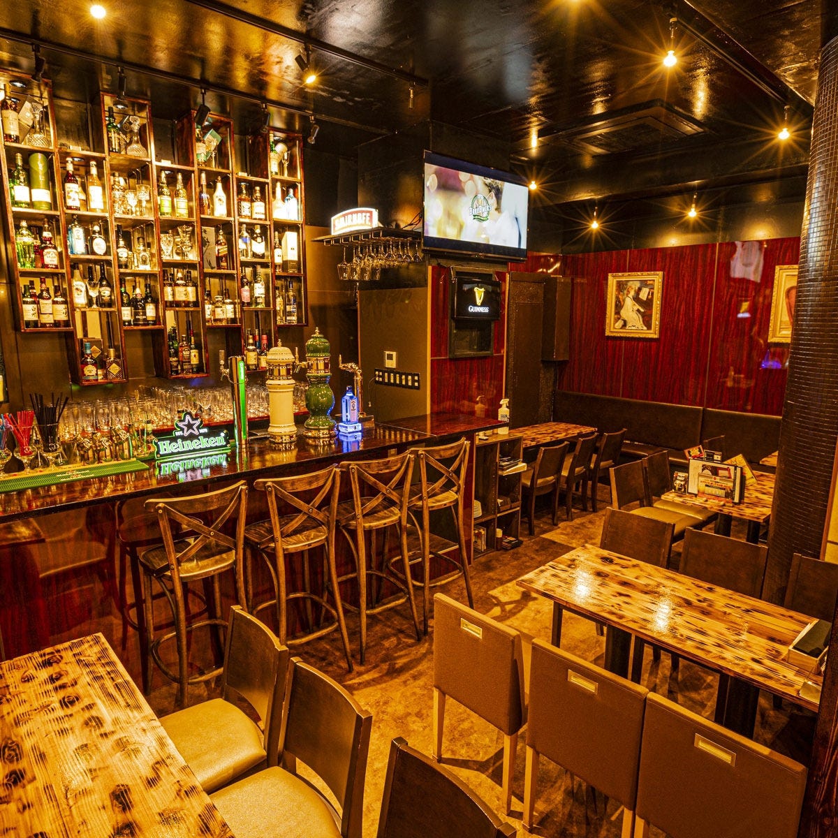 ワインレッドの壁にボトルが並ぶ、おしゃれな店内