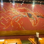 橘ナオキ画伯による圧巻の壁画「万葉の鳳凰」が客席を彩ります
