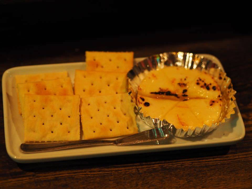 長方形の皿に盛り付けられたカマンベールチーズのマーマレード焼きとクラッカー