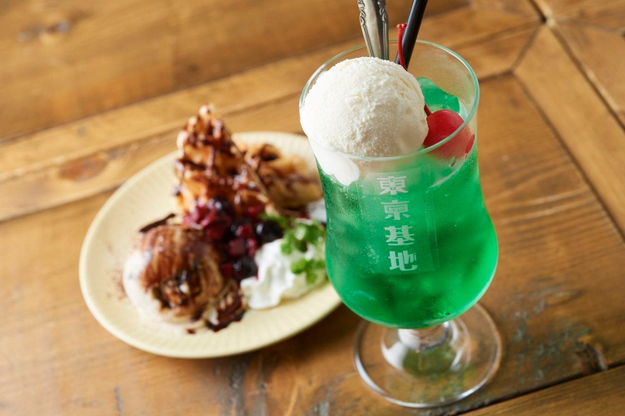木目調のテーブルに置かれた東京基地 離 スペイン坂店のクリームソーダ